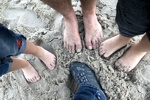 Strandwanderer mit und ohne Schuhe.